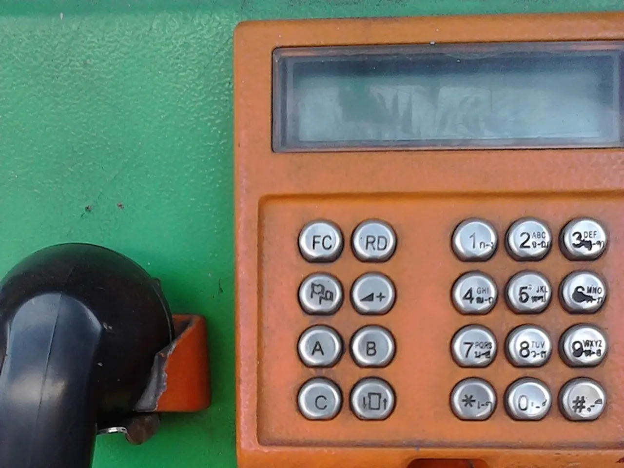 Here in this picture we can see a telephone in green and orange colored present over there.