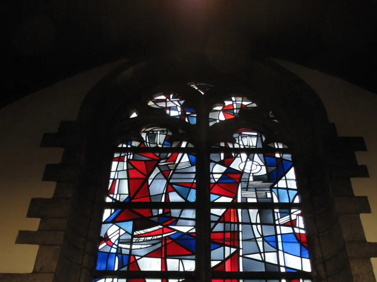 In this picture there is a close view of the glass window with red and blue color pattern.