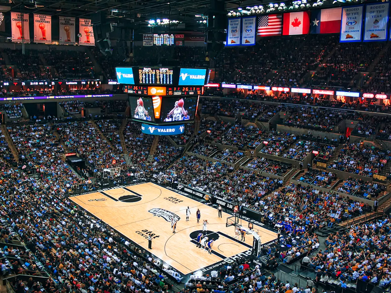 This is the picture of a stadium. In this image there are group of people standing in the court....