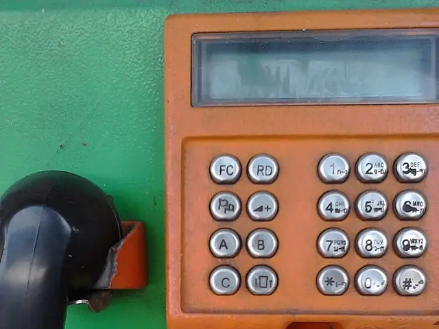 Here in this picture we can see a telephone in green and orange colored present over there.