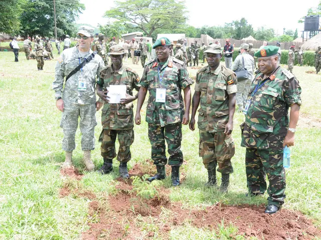In this image, there are some people sanding and they are wearing soldiers hats, at the background...