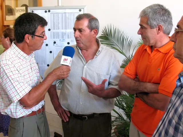 In this image there is a man in the middle who is interviewing the other person by holding the mic....