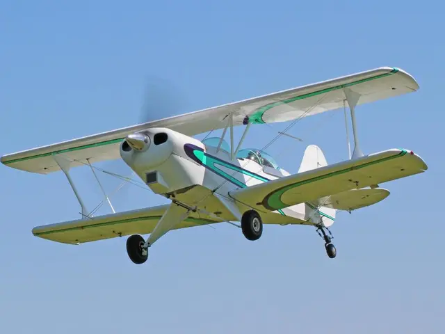 In this image I can see an aircraft in the air and in the background I can see the sky.