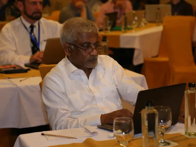 Here is a man is looking into the chair and looking into the laptop and here is a wine glass,...