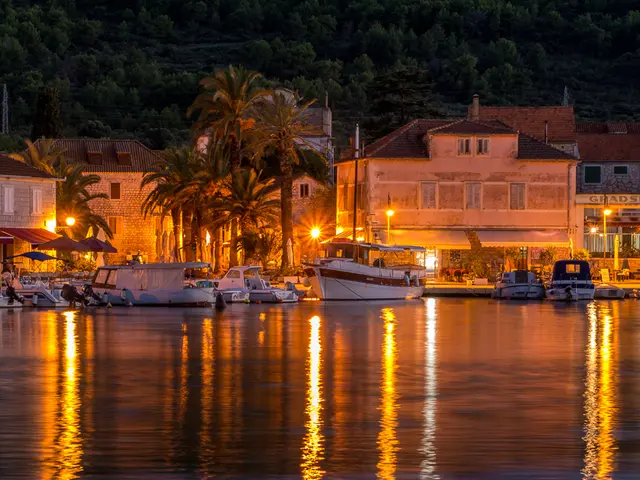 In this picture we can see there are boats on the water. Behind the boats, there are buildings,...