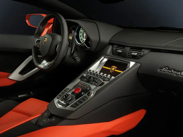 This image is taken from inside the car. In this image we can see there is a steering, seats, music...